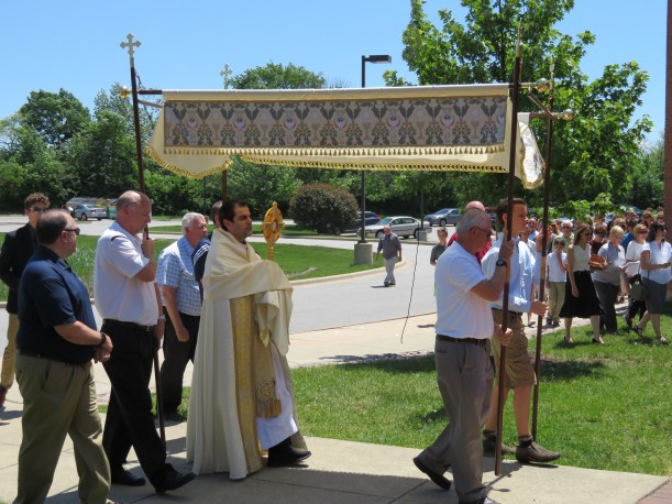 Father Raed Bader carries Blessed Sacrament